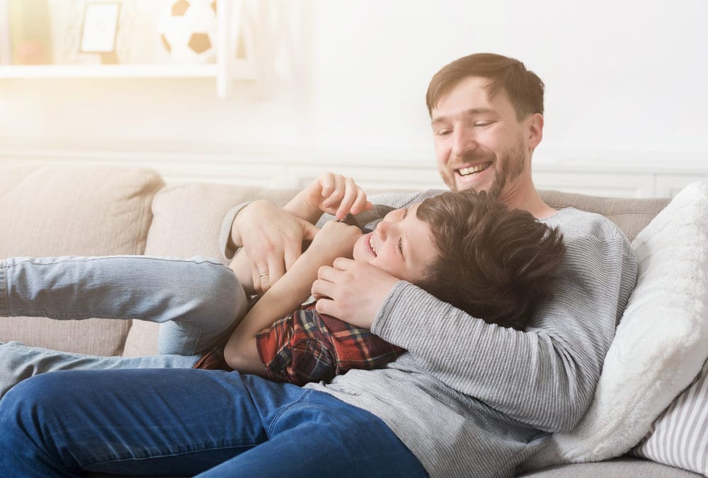 Same-sex parentage and child custody attorneys in Bloomington-Normal Illinois – father and son playing on the couch – Koth Gregory & Nieminski Law Firm