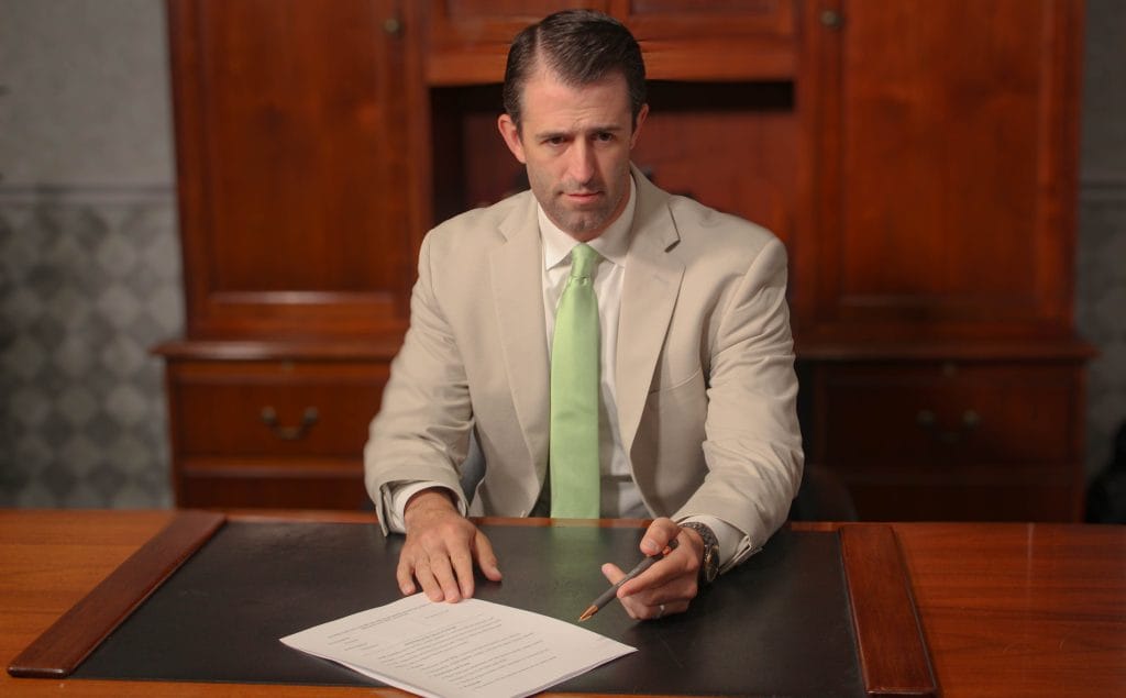 Bloomington-Normal personal injury attorney Dustin Koth showing car accident client paperwork from their personal injury car accident case in McLean County 