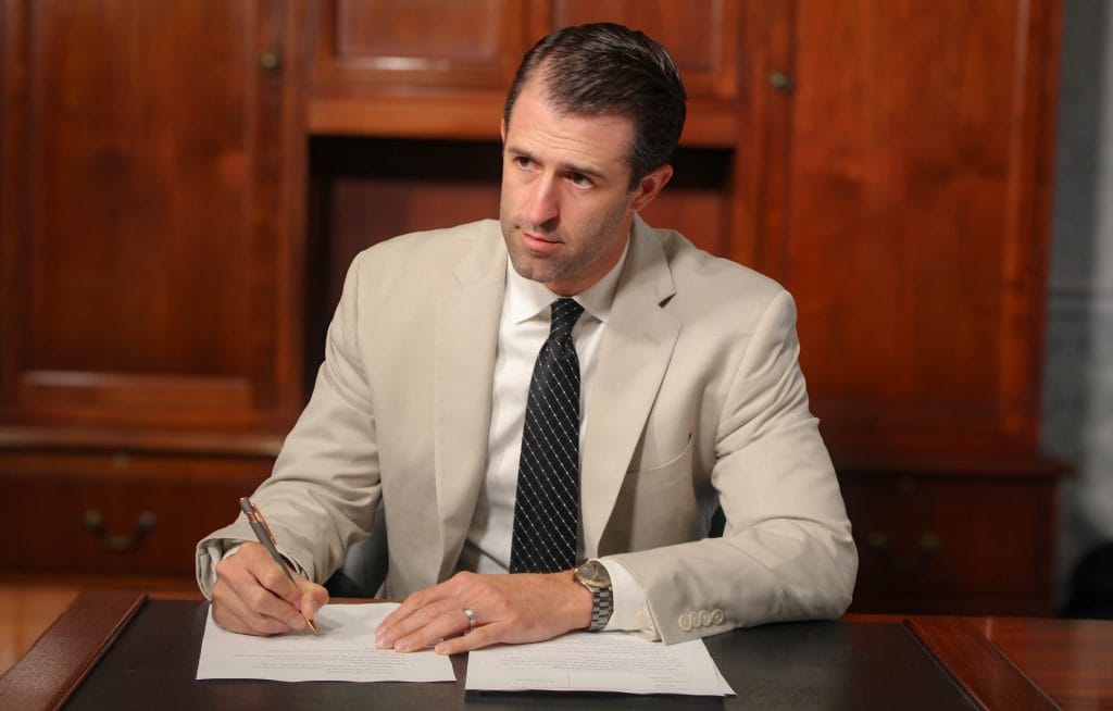 Personal injury attorney Dustin Koth taking notes during a consulation about a car accident in Bloomington-Normal Illinois 