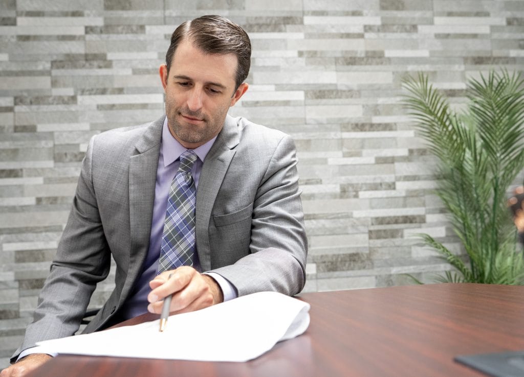 Attorney Dustin Koth showing personal injury car accident victim documents at Koth Gregory & Nieminski office conference room in Bloomington-Normal Illinois 